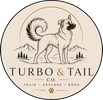 A circular beige logo or label design featuring a black line drawing of a dog standing in front of mountains and trees, with the text 'TURBO & TAIL CO.' and smaller text 'TRAIN • EXPLORE • BOND' plus a paw print.